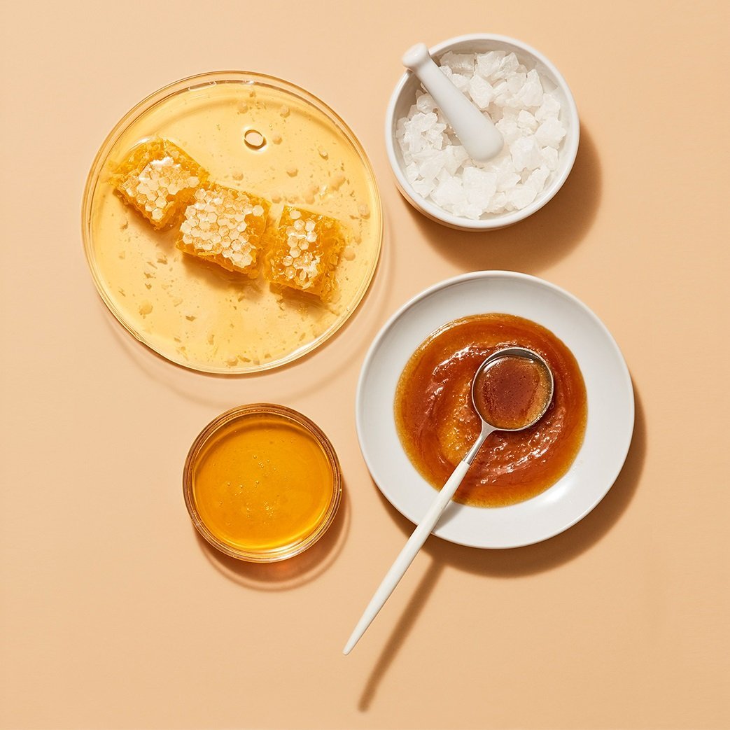 Bowls of honey, coconut oil, and shea butter, common hair mask ingredients.